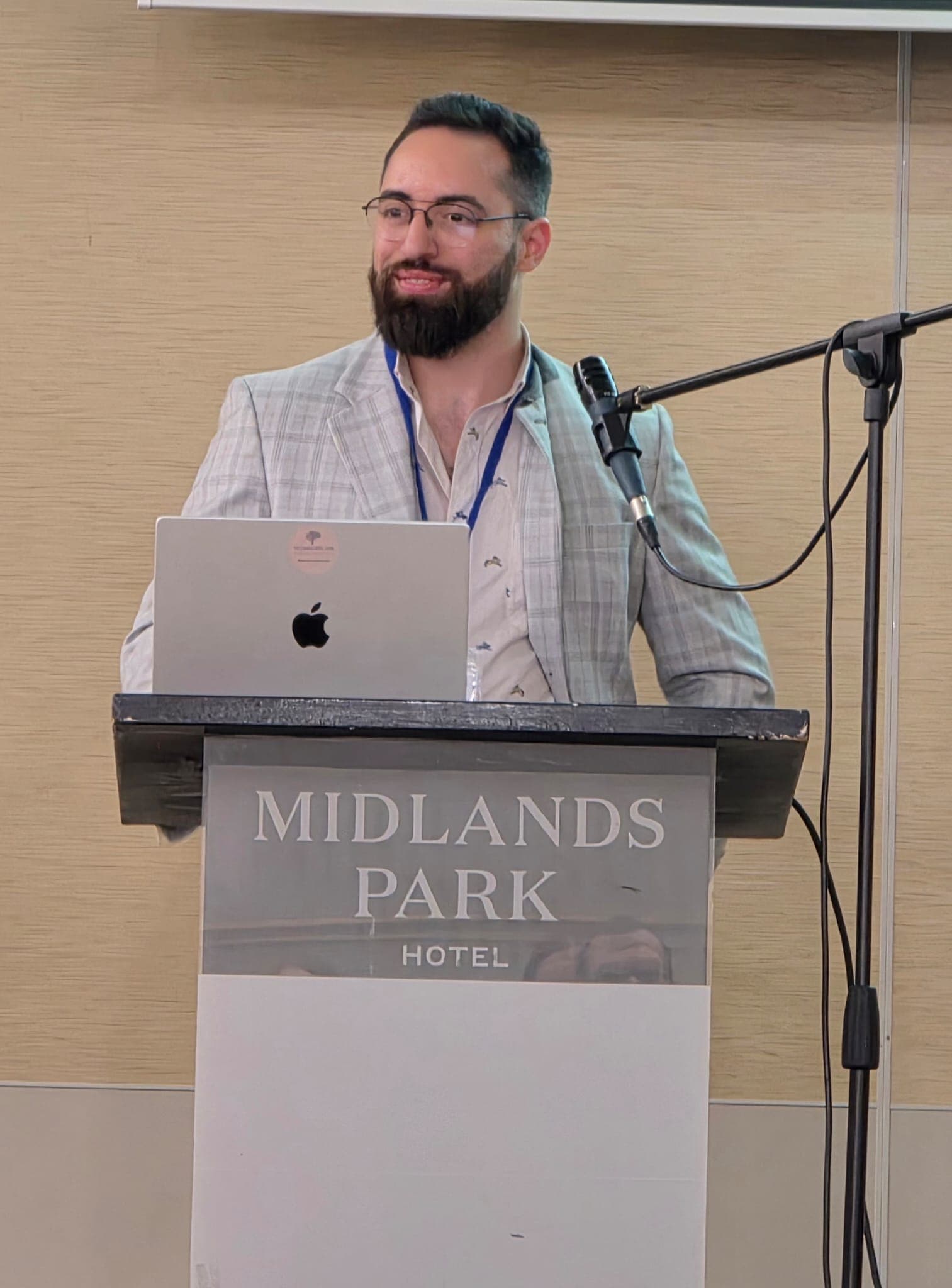 Gabriel Rodrigues Palma presenting from a lectern at a conference